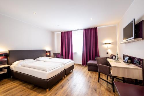 a hotel room with a bed and a desk at Weinhotel Restaurant Klostermühle in Ockfen