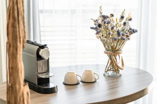 a coffee maker and a vase of flowers on a table at Sofitel Quiberon Thalassa sea & spa in Quiberon
