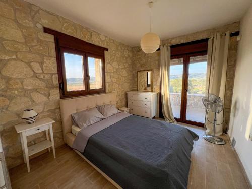 a bedroom with a bed and a stone wall at Manuela's Stone Heaven Retreat in Kalandra