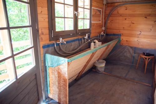 a bathroom with a tub in a wooden house at Camping BODENGO RANGET in Gordona