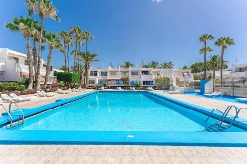 ein großer Swimmingpool mit Stühlen und Palmen in der Unterkunft MARINE HOME in Costa Del Silencio