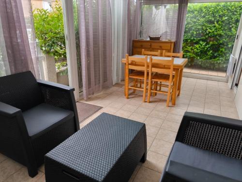 une véranda avec une table et des chaises dans l'établissement Les VAGUES DE LA GARDIOLE, à Vic-la-Gardiole