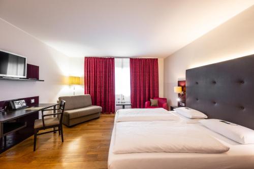 a hotel room with two beds and a desk at Weinhotel Restaurant Klostermühle in Ockfen