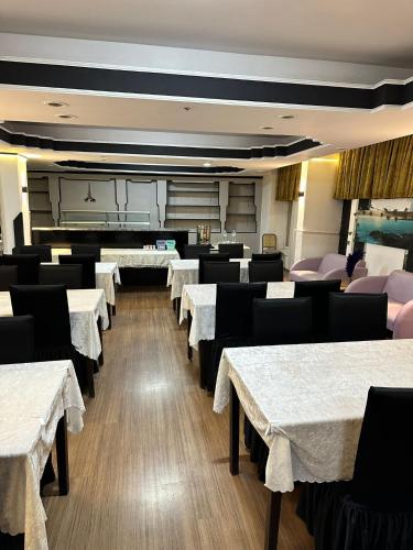 a dining room with white tables and black chairs at NIGRUM HOTEL in Nevsehir