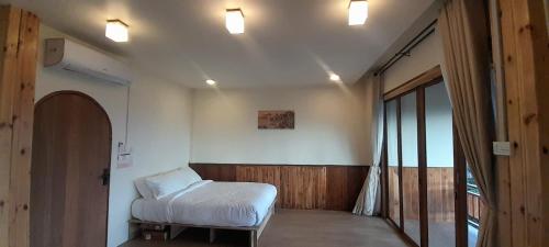 a room with a bed and lights on the ceiling at KHIRI HOUSE &Café Farm ดอยช้างเชียงรายที่พักอาข่าเรียวกังสไตล์กลางหมู่บ้านดอยช้าง in Ban Rong Than