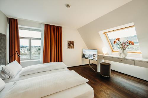 a hotel room with two beds and a window at Seehotel am Kaiserstrand in Lochau