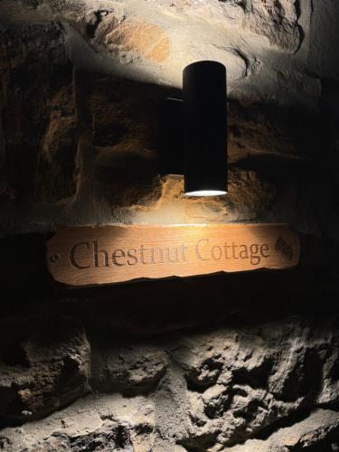 a sign that reads chestnut cottage hanging on a brick wall at Chestnut Cottage Ravensworth in Richmond