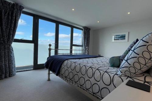 ウーラクームにあるSeasalt - Beach Front Apartmentのベッドと大きな窓のある寝室