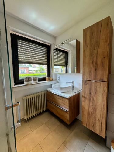a bathroom with a sink and a mirror at Ferienhaus Zipfelstube in Selfkant