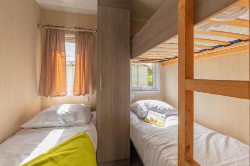 two bunk beds in a small room with a window at Camping Heino in Heino