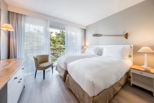 a bedroom with a large white bed and a window at Sofitel Quiberon Thalassa sea & spa in Quiberon