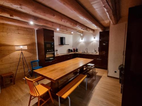 une salle à manger avec une table et des chaises en bois dans l'établissement Grande maison chaleureuse, à Bazus-Aure