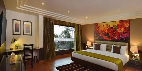a bedroom with a bed and a desk and a window at Fortune Park Moksha, Mcleodganj - Member ITC Hotels' Group in McLeod Ganj