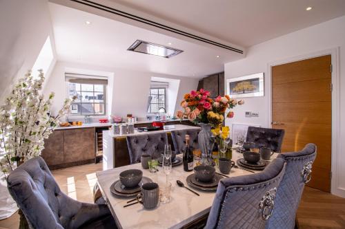 une salle à manger avec une table et des chaises ainsi qu'une cuisine dans l'établissement Elegant 3-Bedroom Penthouse in Marble Arch 70, à Londres