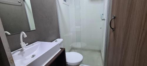 a bathroom with a toilet and a sink and a shower at Locapart Hospedagens in Chapecó