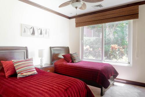 a bedroom with two beds and a window at Luxury, ocean view, 3-bedroom condo @ Los Sueños in Herradura