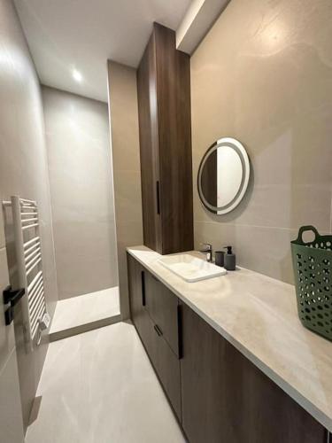 une salle de bain avec un lavabo et un miroir dans l'établissement Magnifique T2 cœur de ville, à Sète