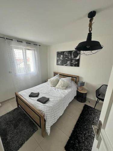 Un dormitorio con una cama en una habitación blanca. en Luxueuse Villa Neuve avec Jardin, en Colombes