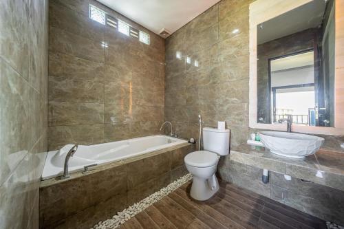 努沙杜瓦Aradhia Villa Nusa Dua的带浴缸、马桶和水槽的浴室