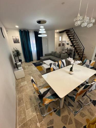 un salon avec une table et des chaises blanches dans l'établissement Luxueuse Villa Neuve avec Jardin, à Colombes