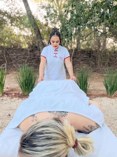 a young girl is getting a tattoo on her back at Pousada Aconchego in Pirenópolis