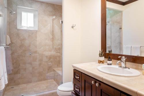 a bathroom with a sink and a shower and a toilet at Luxury, ocean view, 3-bedroom condo @ Los Sueños in Herradura