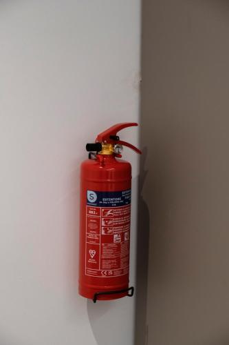 a red fire hydrant hanging on a wall at barneys design apartment in Taranto