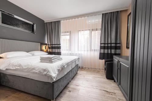 a bedroom with a bed and a large window at Grand Taverna Boutique -Adults Only in Vama Veche