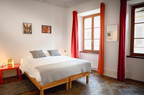 - une chambre avec un grand lit et des rideaux rouges dans l'établissement Les Appartements Rue des Veaux - Quartier Cathédrale, à Strasbourg