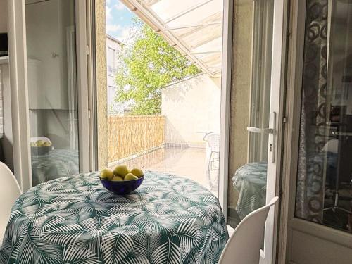- un bol de fruits assis sur une table sur une terrasse couverte dans l'établissement Appartement cozy avec terrasse, idéal pour les JO!, à Aubervilliers