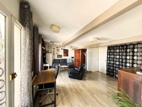 un salon avec un canapé et une table dans l'établissement Appartement cozy avec terrasse, idéal pour les JO!, à Aubervilliers