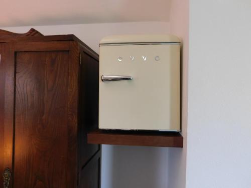 a refrigerator freezer sitting next to a wooden cabinet at Hotel Rustico Casa Do Vento in Bayo