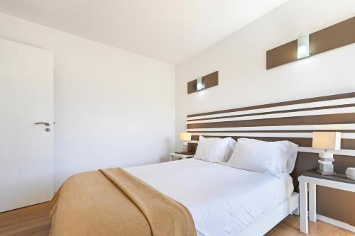 a bedroom with a white bed with a wooden headboard at Casas das Olas in Arcos de Valdevez