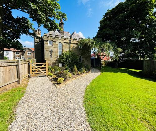 an old house with a fence and a grass yard at Sneaton Castle in Whitby