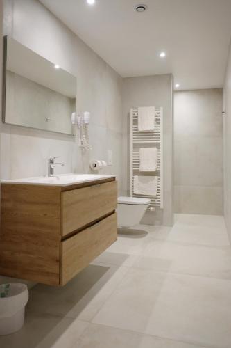 une salle de bain avec un lavabo, une baignoire et un miroir dans l'établissement Chambres d'hôtes François Bleger, à Saint-Hippolyte