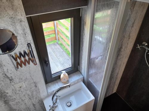 a small bathroom with a sink and a window at Eisenbahnromantik im Urlaub in Heinsdorfergrund