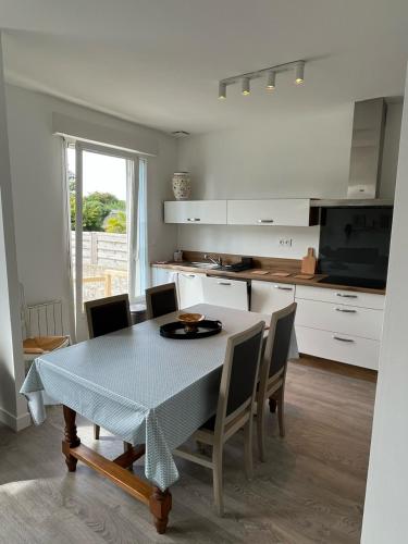 une cuisine et une salle à manger avec une table et des chaises dans l'établissement Maison de ville à la mer très bien équipée proche centre avec commerces, à Plouescat