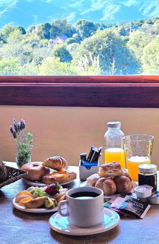 een tafel met een ontbijt van bagels en een kop koffie bij Complejo Falda del Sauce in Villa General Belgrano