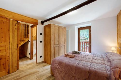 a bedroom with a large bed and wooden cabinets at Les Cles - Achillea in Valsavarenche