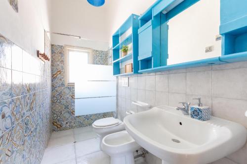 a white bathroom with a sink and a toilet at Villetta Stella by BarbarHouse in Torre Colimena
