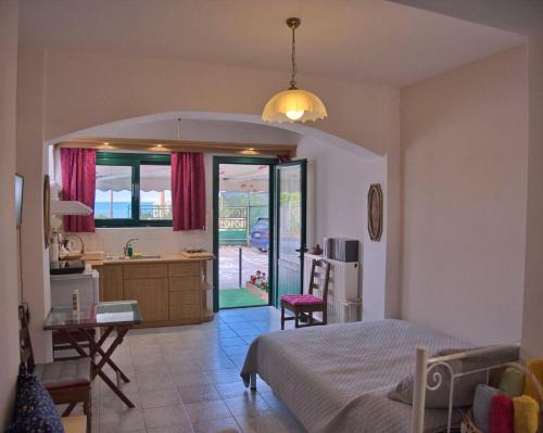 a bedroom with a bed and a desk and a kitchen at Sunrise & Sunset apartments in Monemvasia