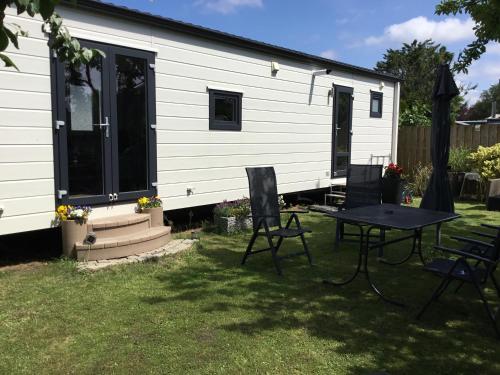 a house with a table and chairs in the yard at Chalet Buitenhof 45A in Oegstgeest