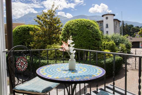 a table with a vase on top of a balcony at Albergo Mirador Ascona in Ascona