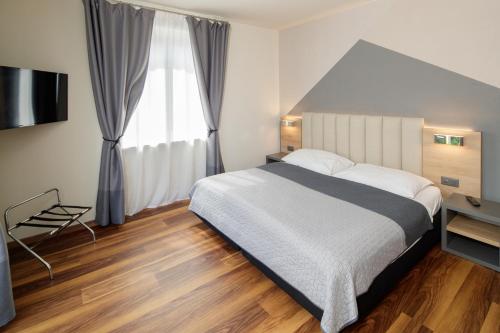 a bedroom with a large bed and a window at Albergo Mirador Ascona in Ascona