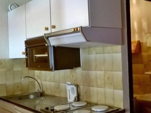 une petite cuisine avec des armoires blanches et un évier dans l'établissement Studio pour 3 avec balcon exposé Sud/Ouest, proche centre et remontées, parking privé - FR-1-676-73, à Châtel