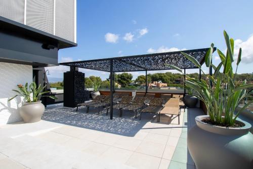 a patio with chairs and plants on a building at Golden Port Salou & Spa in Salou