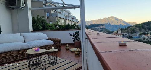 a balcony with a couch and a view of a mountain at 3 bedrooms apartment with wifi at Amalfi 3 km away from the beach in Amalfi