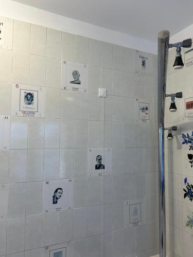 a white tiled bathroom with pictures on the wall at Spazio DIBA in Ortona