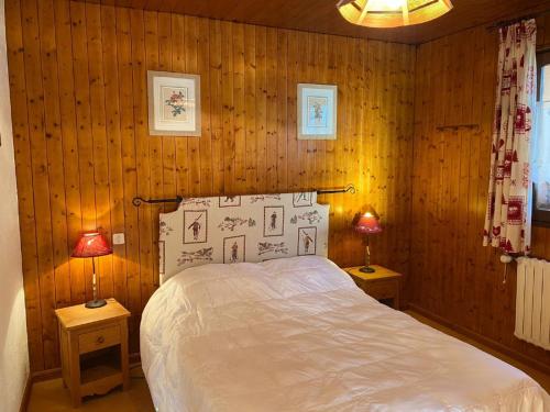 - une chambre avec des murs en bois et un lit avec deux lampes dans l'établissement Chalet 3 pièces pour 6 pers avec Wifi et Parking à Châtel - FR-1-676-164, à Châtel
