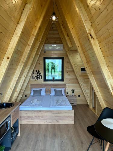 a bedroom in a log cabin with a bed at Honey Glamping Resort with jacuzzi in Tomislavgrad